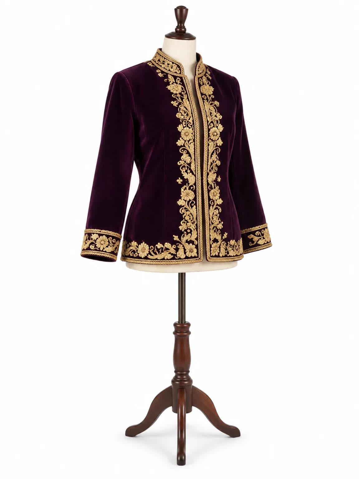 Un karakou de velours aubergine brodé de cordon doré, sur un buste de couturière.